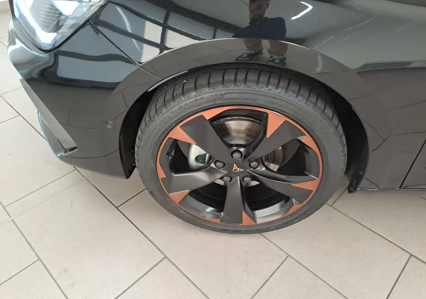 Gros plan sur la roue avant gauche d'une CUPRA Leon Noir Minuit avec jante alliage 18'' cuivrée et détail du pneu.