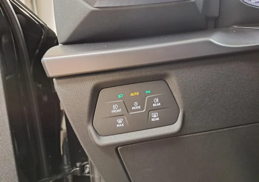 Gros plan sur les commandes d'éclairage et désembuage côté gauche d'une CUPRA Leon Noir Minuit 2025.