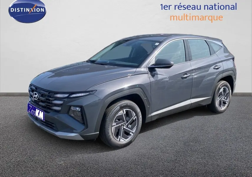 Vue 3/4 avant droit du Hyundai Tucson gris Ecotronic Metal avec calandre distinctive et jantes bi-ton.