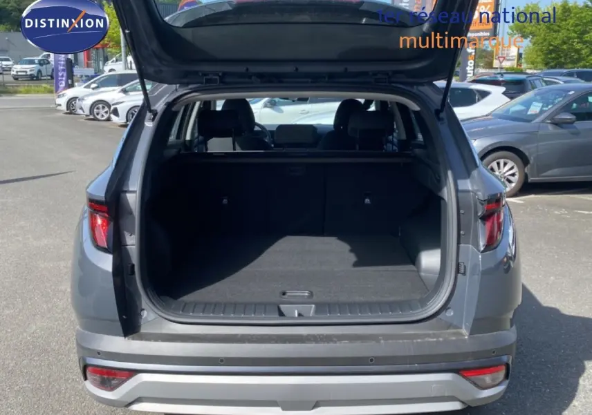 Vue arrière du Hyundai Tucson gris Ecotronic Metal 2026 avec coffre ouvert et intérieur spacieux visible.