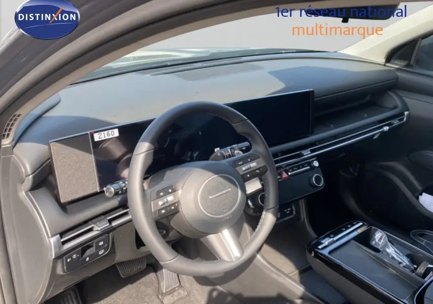 Vue intérieure de face du tableau de bord et du volant noir du Hyundai Tucson 2026, avec écran tactile large et finition moderne.
