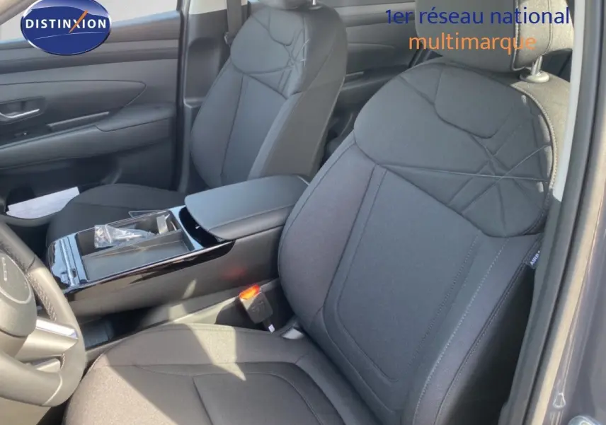 Vue intérieure côté gauche du Hyundai Tucson 2026, sièges tissu noir avec console centrale brillante.