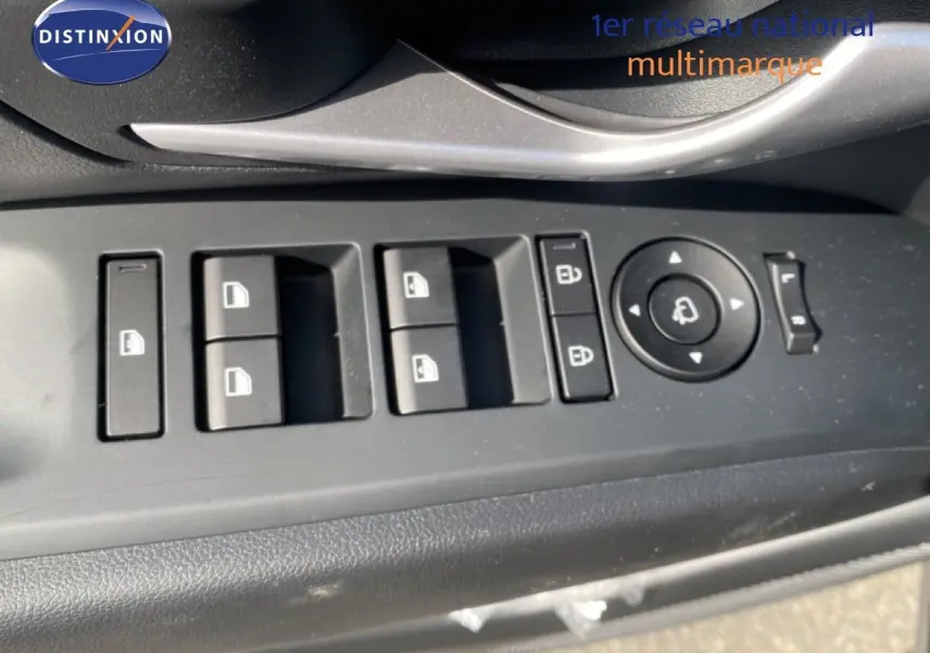 Gros plan sur les commandes de lève-vitres et rétroviseurs côté gauche d’un Hyundai Tucson gris Ecotronic 2026.