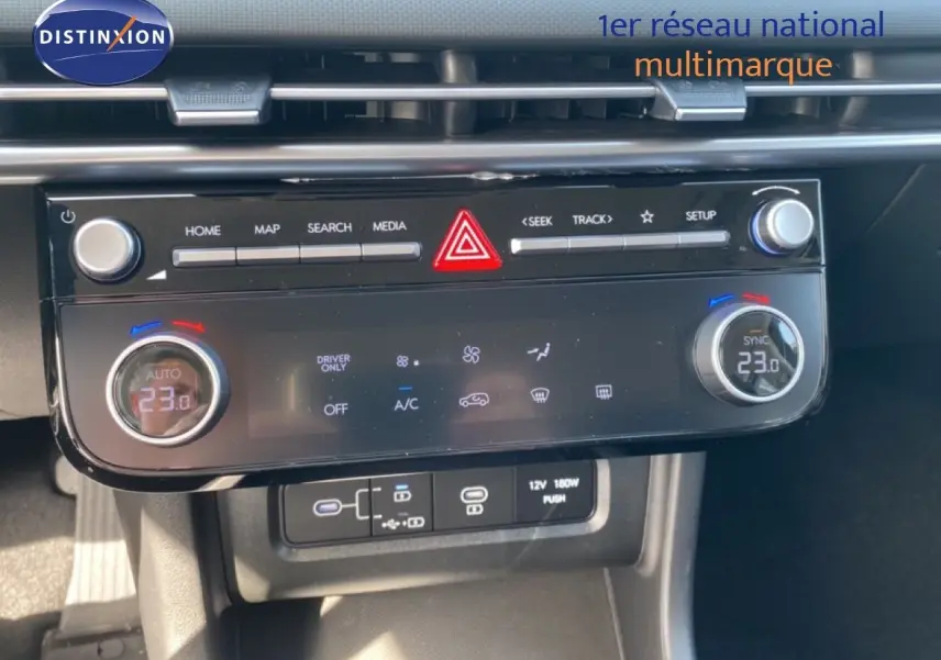 Vue rapprochée de la console centrale du Hyundai Tucson 2026, avec commandes climatisation digitales et boutons multimédia.