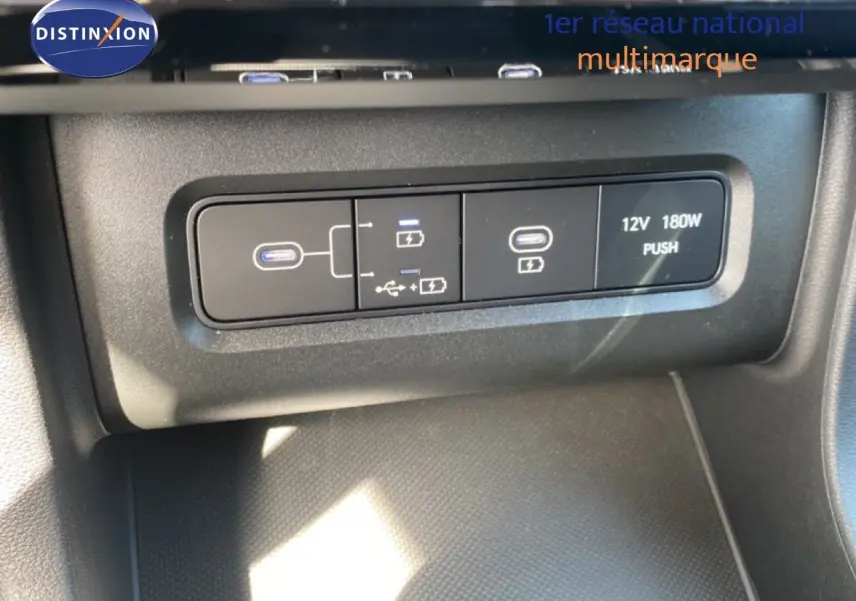 Gros plan sur les ports USB et prise 12V du Hyundai Tucson gris Ecotronic 2026, côté console centrale.