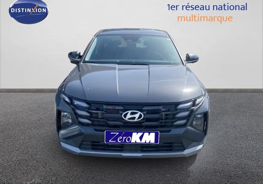 Vue frontale d'un Hyundai Tucson gris Ecotronic Metal avec calandre noire et phares LED intégrés.
