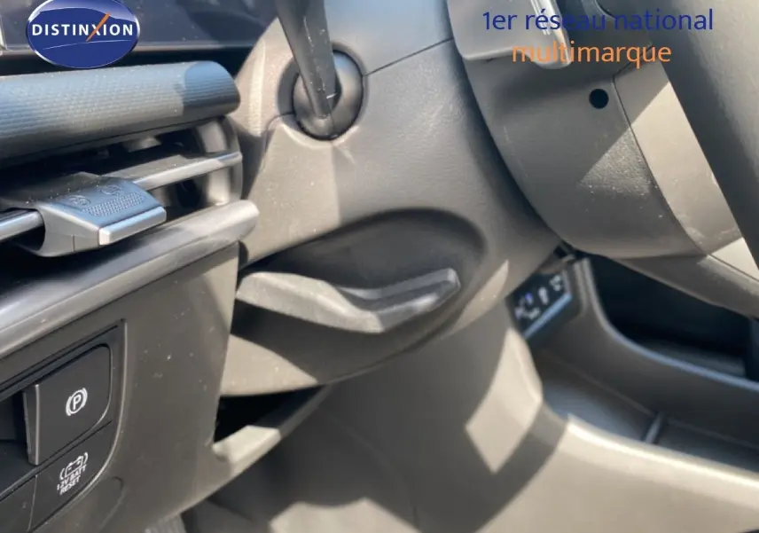 Détail intérieur côté gauche du Hyundai Tucson gris Ecotronic, montrant commandes de frein à main et partie du tableau de bord.