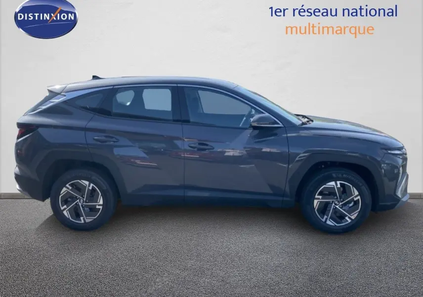 Vue de profil côté gauche d'un Hyundai Tucson gris Ecotronic Metal 2026 avec jantes alliage bicolores.