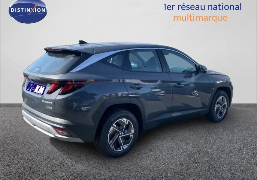 Vue 3/4 arrière droite d’un Hyundai Tucson gris Ecotronic Metal 2026 avec jantes bi-ton et feux LED distinctifs.
