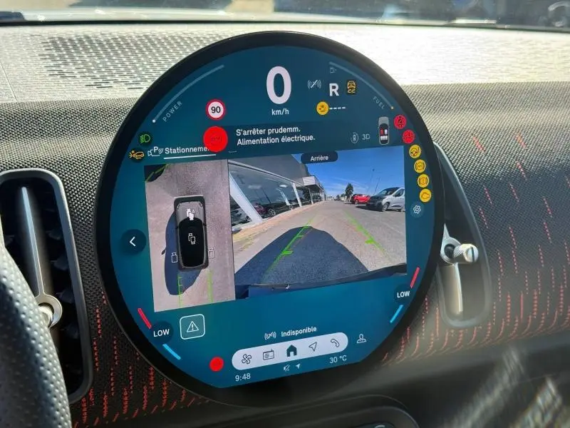Écran circulaire du tableau de bord MINI Countryman affichant la caméra de recul et les alertes de stationnement.