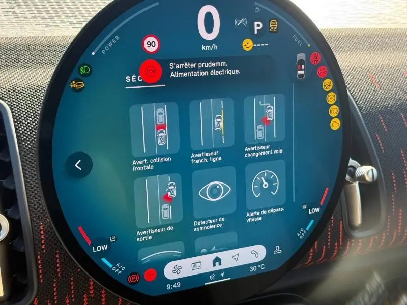 Gros plan sur l’écran multifonction circulaire du tableau de bord du MINI Countryman argenté, affichant les aides à la conduite.