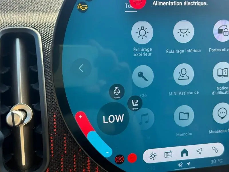 Gros plan sur l’écran tactile central du MINI Countryman argenté, affichant les commandes de climatisation et d’éclairage.