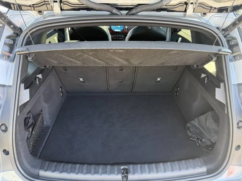 Coffre ouvert vu de l'arrière d'une MINI Countryman argentée, montrant un espace de chargement propre et bien agencé.