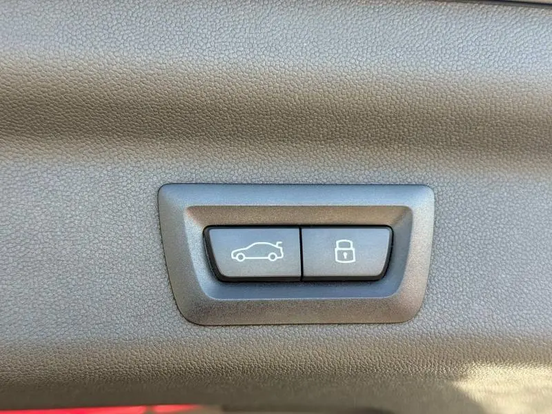 Boutons de commande de coffre et de verrouillage intégrés dans le panneau intérieur d'une MINI Countryman argentée.