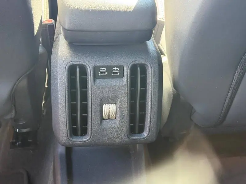 Vue rapprochée des aérateurs arrière noirs et des ports USB-C du MINI Countryman C 170ch JCW argenté, entre les sièges avant.