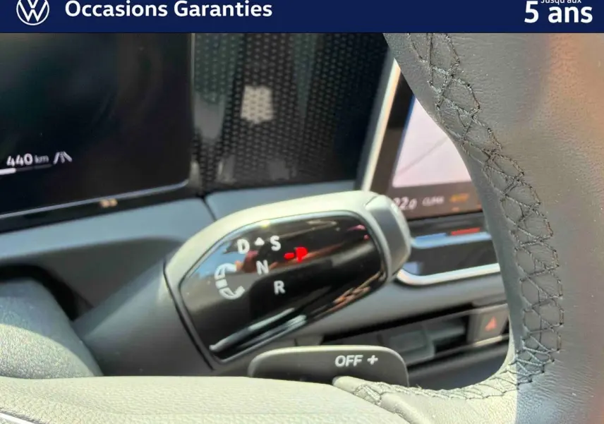Gros plan sur le levier de vitesses noir brillant d’un Volkswagen Tiguan gris, avec affichage des modes de conduite.