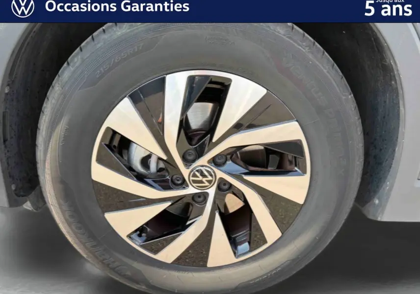 Gros plan sur la jante alliage Venezia noire et brillante de 17 pouces du Volkswagen Tiguan gris, côté avant droit.