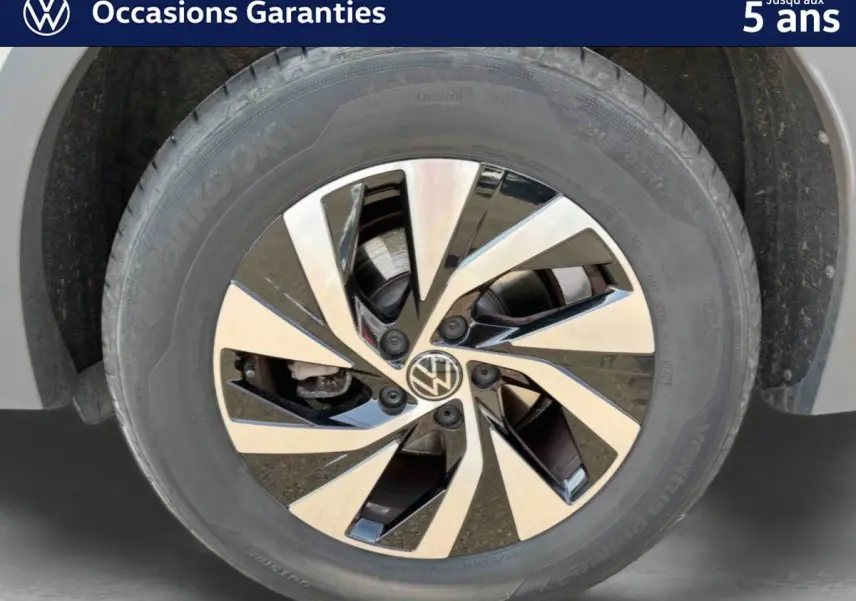 Gros plan sur la jante alliage Venezia noire et brillante du Volkswagen Tiguan gris, mettant en valeur son design moderne.