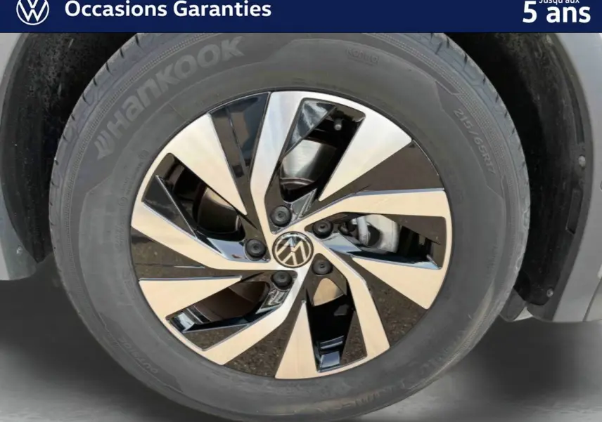 Gros plan sur la jante alliage Venezia noire et brillante du Volkswagen Tiguan gris, mettant en valeur son design moderne.
