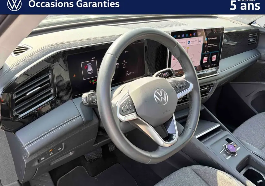 Vue intérieure du tableau de bord et volant cuir du Volkswagen Tiguan 2025 avec écran tactile et finitions grises.