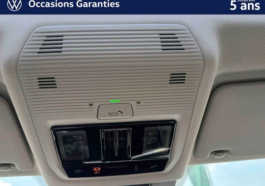 Vue en contre-plongée du plafonnier gris clair avec commandes SOS et éclairage intérieur du Volkswagen Tiguan 2025.