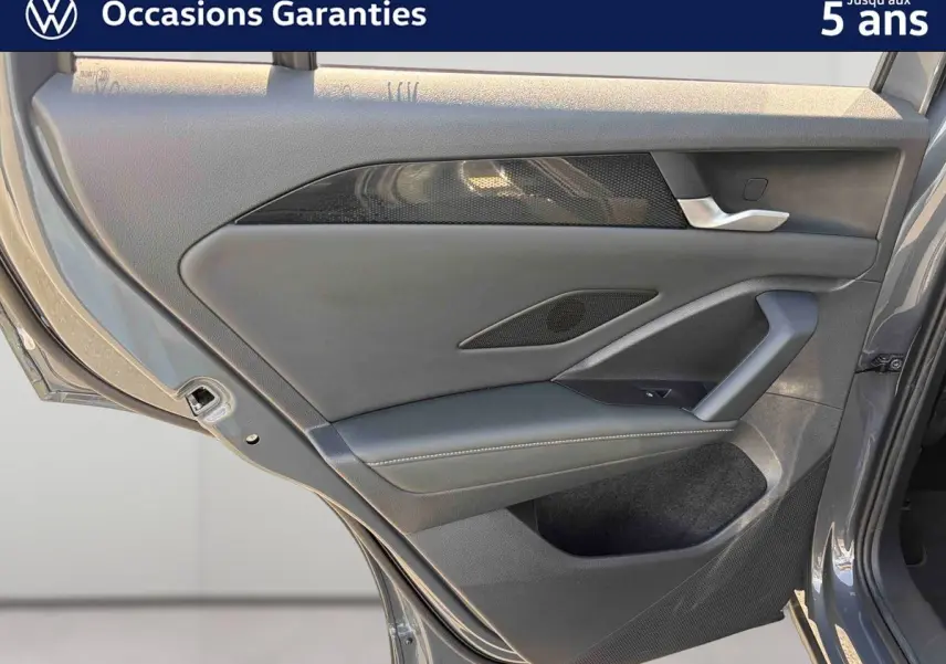 Vue rapprochée de la porte arrière gauche grise du Volkswagen Tiguan 2025 avec garniture noire et poignée argentée.