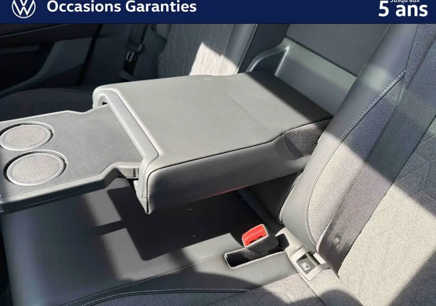 Détail de l'accoudoir central arrière déployé avec porte-gobelets du Volkswagen Tiguan gris, intérieur tissu et cuir.