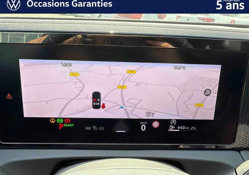 Tableau de bord numérique du Volkswagen Tiguan 2025 affichant la navigation et les alertes, vue intérieure frontale.