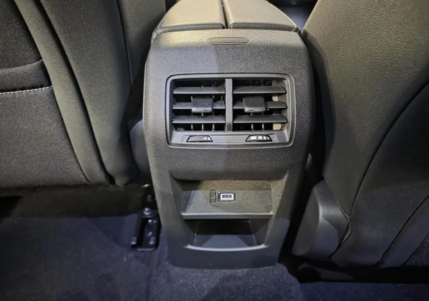 Vue rapprochée de la console centrale arrière noire de l’Opel Astra Hybrid 2024 avec bouches d’aération et port USB.