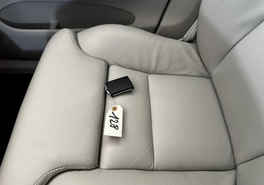 Gros plan sur le siège avant droit en cuir beige clair avec clé noire et étiquette dans l'habitacle d'un Volvo XC60.