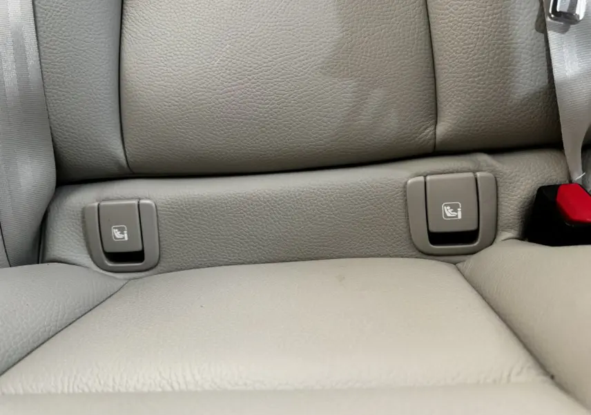 Détail des fixations ISOFIX sur la banquette arrière en cuir beige du Volvo XC60 bleu hybride rechargeable.