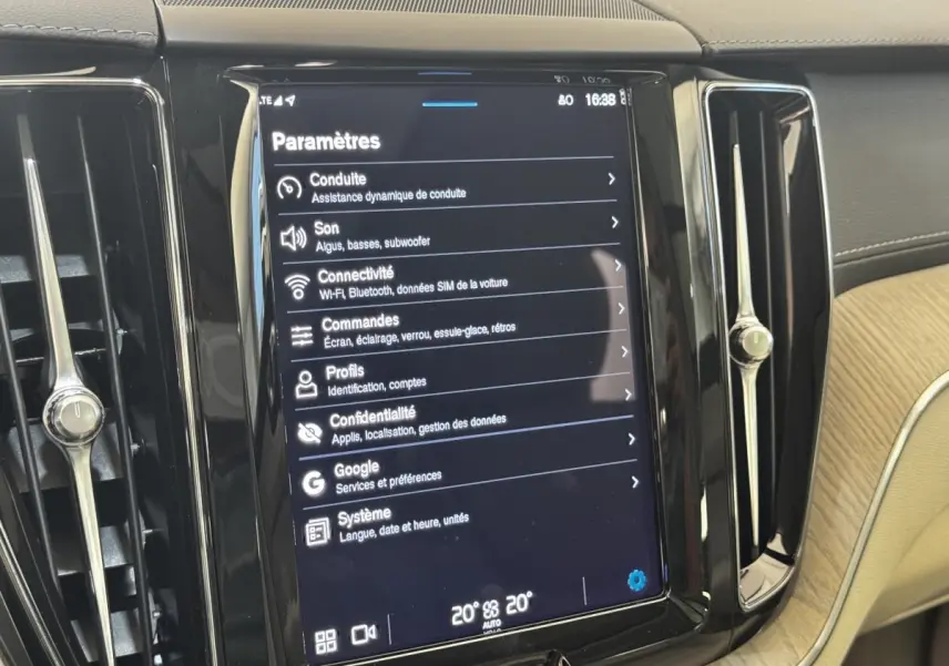 Écran tactile central affichant les paramètres dans l’habitacle clair d’un Volvo XC60 bleu hybride rechargeable.