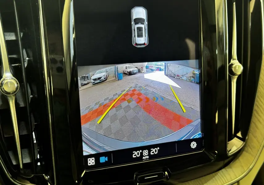 Écran tactile intérieur montrant la caméra de recul avec vue arrière et repères jaunes du Volvo XC60 bleu.