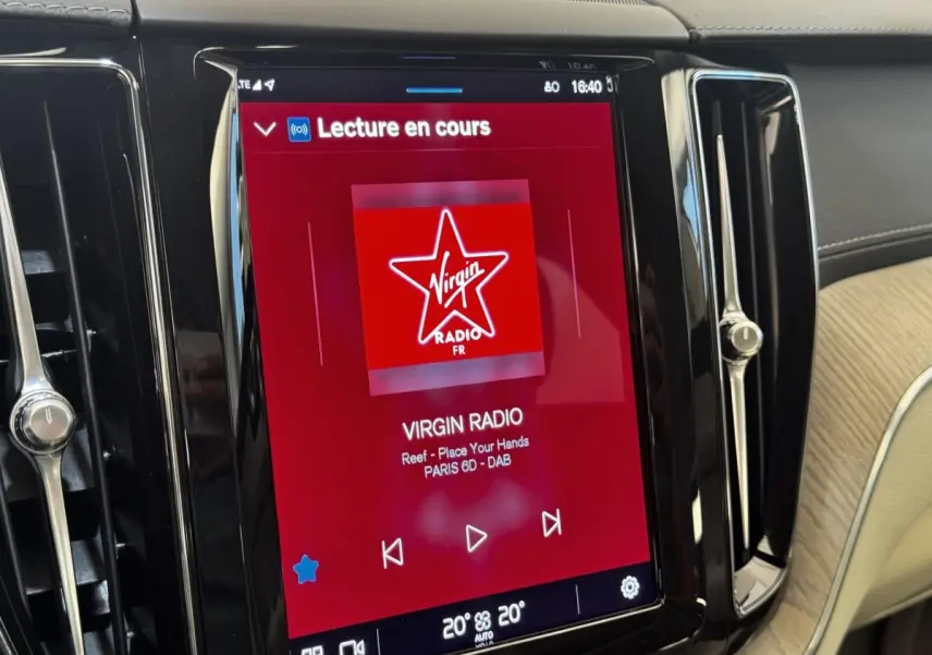 Écran tactile central du tableau de bord du Volvo XC60 bleu, affichant la radio Virgin Radio en cours de lecture.