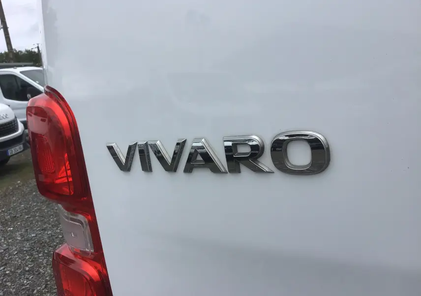 Gros plan sur l'arrière gauche blanc d'un Opel Vivaro 2022 avec logo chromé et feu arrière rouge visible.