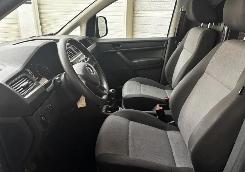 Intérieur avant du Volkswagen Caddy 2019 gris foncé, vue côté conducteur montrant sièges et tableau de bord.