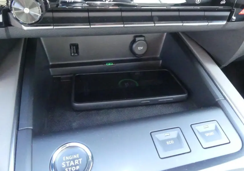 Gros plan sur la console centrale du Citroën C5 Aircross noir avec bouton start/stop, chargeur sans fil et commandes Eco/Sport.