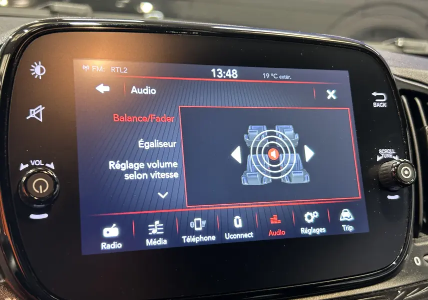 Écran tactile central de la Fiat 500 2023 affichant les réglages audio avec interface moderne en intérieur noir.