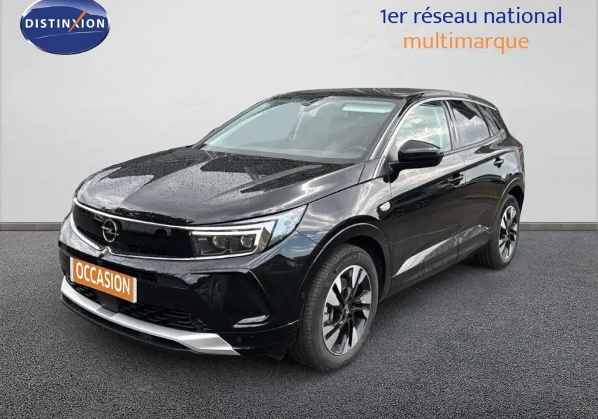 Opel Grandland 2024 noir en 3/4 avant droit, avec jantes bi-ton et calandre moderne sous la pluie.