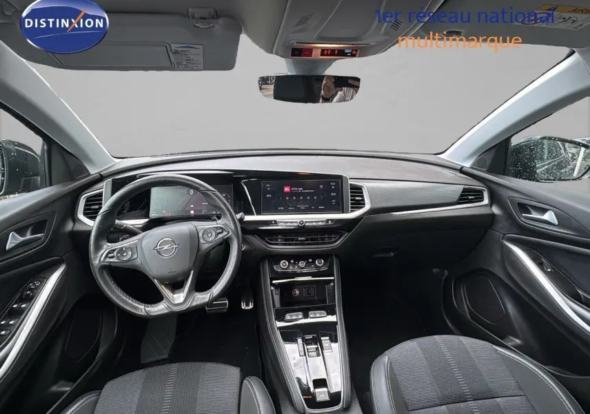 Vue intérieure avant de l'Opel Grandland noir 2024, avec tableau de bord numérique et volant multifonction en cuir.