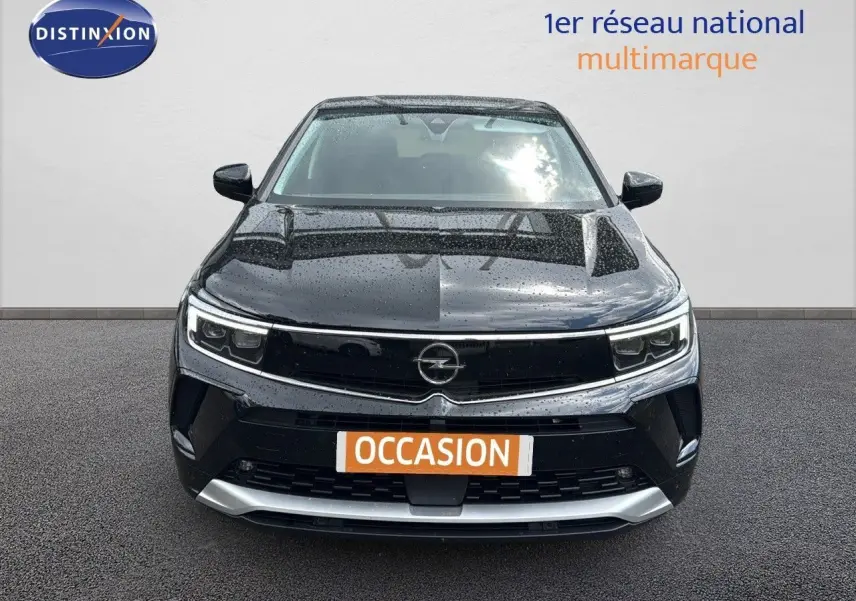 Vue avant d’un Opel Grandland noir 2024 hybride rechargeable avec calandre noire et détails argentés sous la pluie.