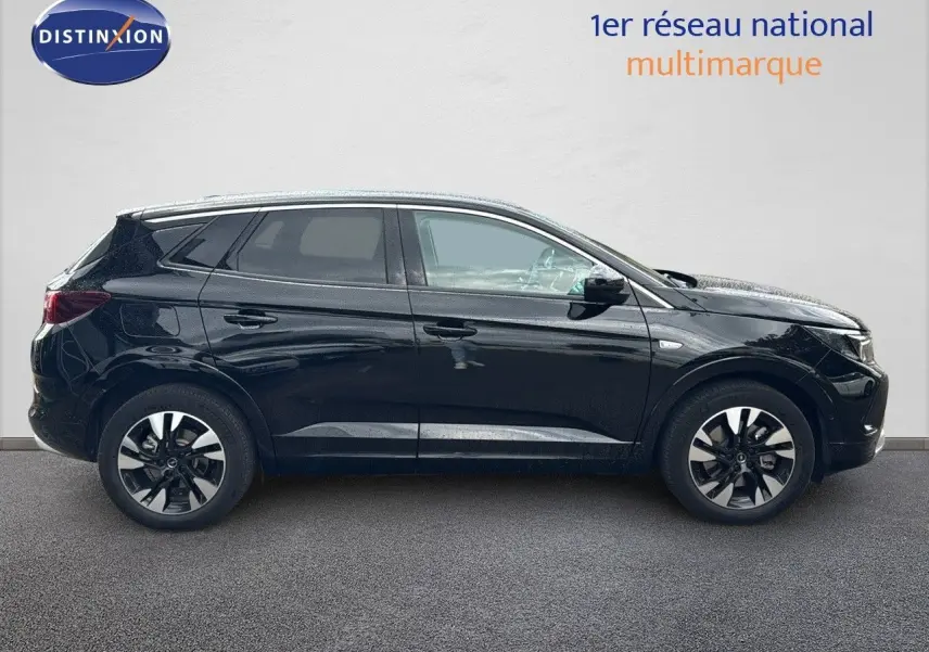 Vue latérale droite d’un Opel Grandland noir 2024 hybride rechargeable avec jantes bi-ton et vitres teintées.