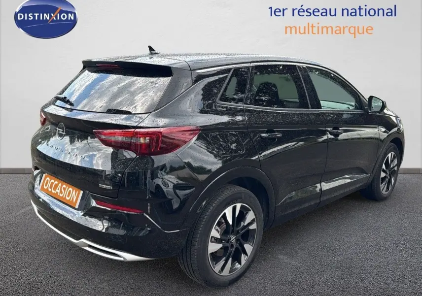 Vue 3/4 arrière droite d’un Opel Grandland noir 2024 hybride rechargeable avec jantes bi-ton et feux LED.