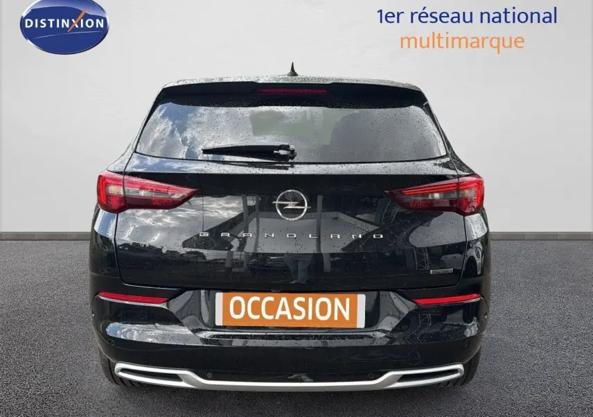 Vue arrière d'un Opel Grandland noir 2024 avec feux LED et logo distinctif sur fond gris.