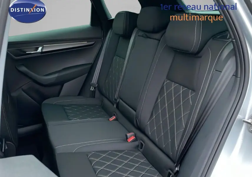 Vue intérieure sur la banquette arrière en cuir noir avec surpiqûres, porte ouverte côté droit du Skoda Karoq gris argent 2025.