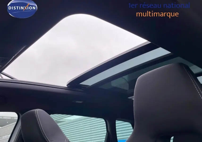 Vue intérieure du toit ouvrant panoramique et des sièges avant en tissu noir du Skoda Karoq gris argent 2025 Sportline.