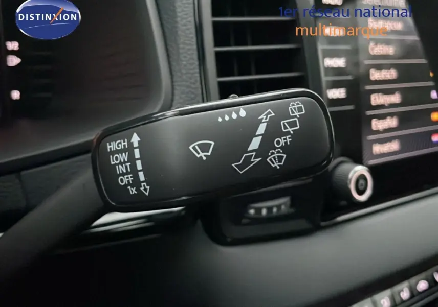 Gros plan sur la commande d’essuie-glace du Skoda Karoq 2025, intérieur noir avec écran tactile en arrière-plan.
