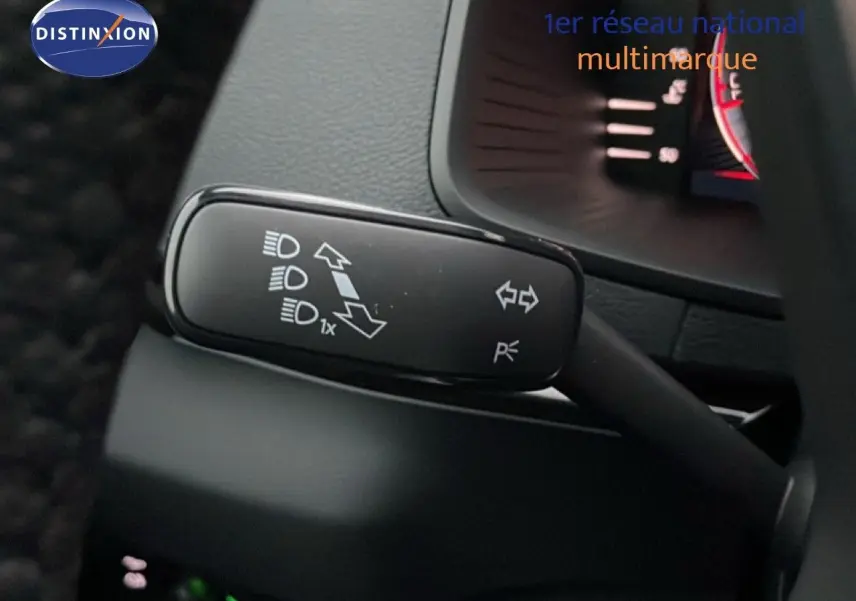Gros plan sur la commande des clignotants et feux d’un Skoda Karoq gris argent 2025, intérieur noir.