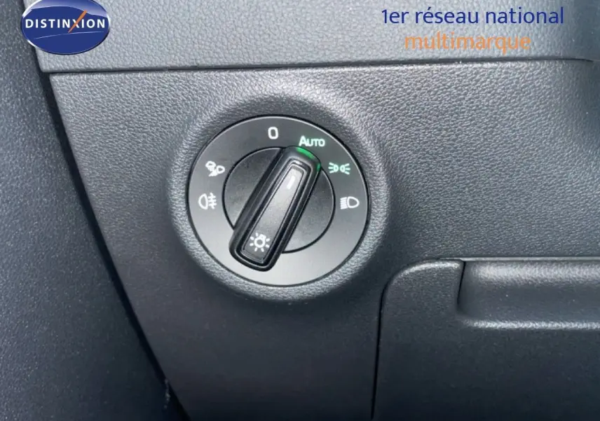 Détail du commutateur des phares sur tableau de bord noir du Skoda Karoq gris argent 2025.