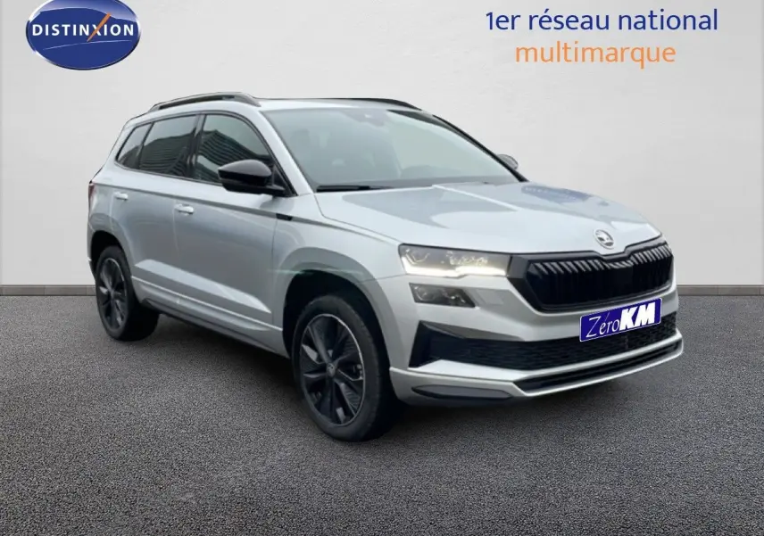 Vue 3/4 avant d’un Skoda Karoq gris argent métallisé 2025 avec jantes noires et calandre noire sportive.